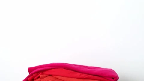 A stack of clothes in different colors. The concept of conscious clothing Stock Footage 236964079
