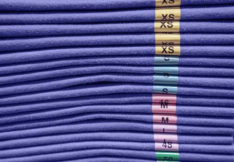 A stack of clothes of different sizes in a store Stock Photos