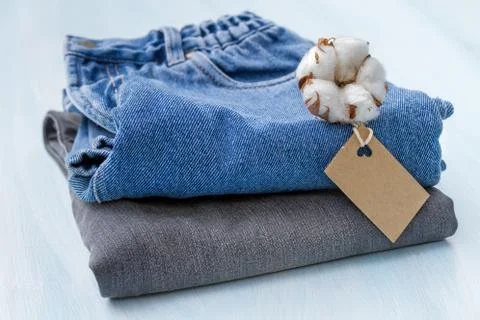Stack of clothes with a sprig of cotton Stock Photos