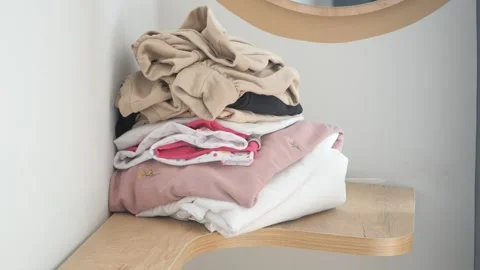 Stack of clothes on table at home Stock Footage 243318670