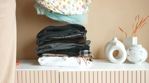 Stack of clothes on table indoor. Stock Footage 239599946