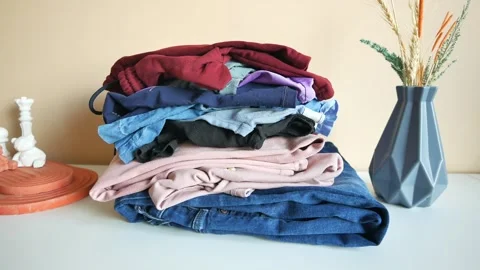 Stack of clothes on table indoor. Stock Footage 257510183
