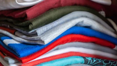 Stack of clothes in wardrobe. stack of colorful folded clothing items. Stock Photos