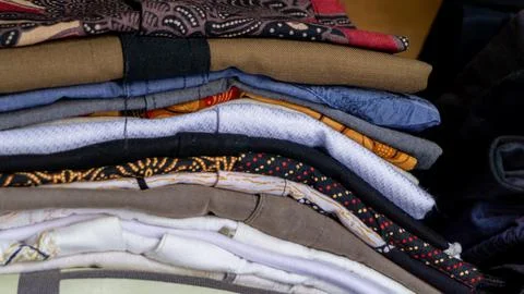 Stack of clothes in wardrobe. stack of colorful folded clothing items. Stock Photos