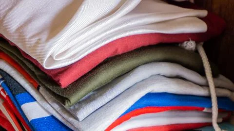 Stack of clothes in wardrobe. stack of colorful folded clothing items. Stock Photos