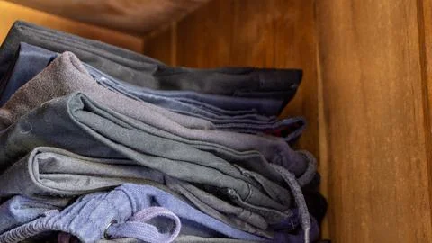 Stack of clothes in wardrobe. stack of colorful folded clothing items. Stock Photos