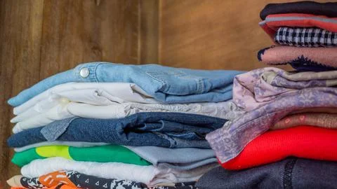Stack of clothes in wardrobe. stack of colorful folded clothing items. Stock Photos