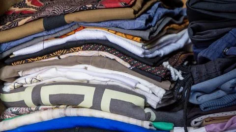 Stack of clothes in wardrobe. stack of colorful folded clothing items. Stock Photos