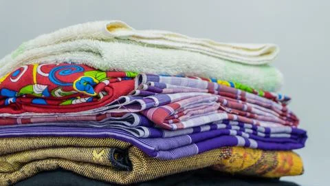 Stack of clothes in wardrobe. stack of colorful folded clothing items. Stock Photos
