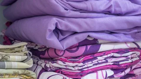 Stack of clothes in wardrobe. stack of colorful folded clothing items. Stock Photos