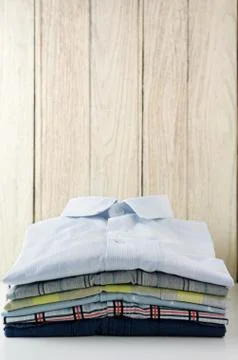Stack of clothes with white wooden background 스톡 사진