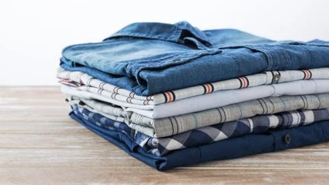 Stack of clothes on wooden table Stock Photos
