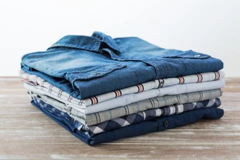 Stack of clothes on wooden table Stock Photos