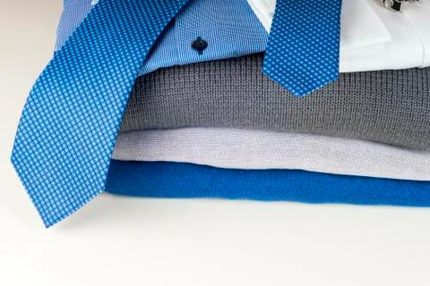 Stack of clothing isolated on white, sweaters, Shirts, knitwear, space for text Stock Photos