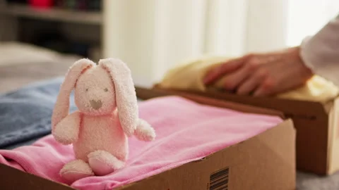 Stack clothing for sorting and donation in cardboard boxes with toy Stock Footage 197323154