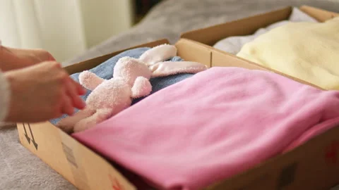 Stack clothing for sorting donation in cardboard boxes with toy Stock Footage 197323421