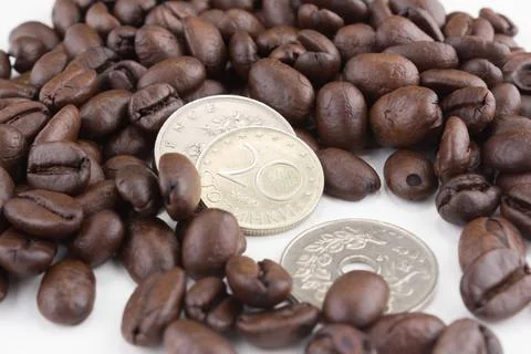Stack of coffee beans with coins Stock Photos