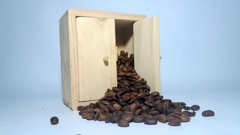 A stack of coffee beans spilling out inside a miniature cabinet Stock Photos