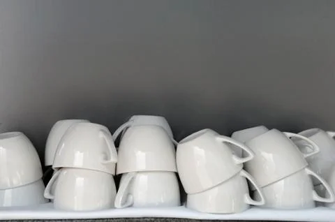 Stack of coffee cups against grey background Stock Photos