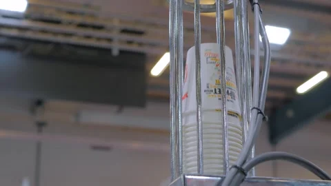 Stack of coffee cups moves along conveyor system of paper cup making machine Stock Footage 344344974
