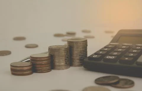 Stack coin with black calculator and another coin. Financial and saving conce Stock Photos