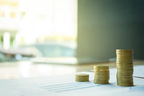 Stack of coin on business document graph. Money and financial concepts. Stock Photos