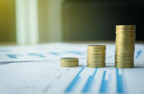 Stack of coin on business document graph. Money and financial concepts. Stock Photos