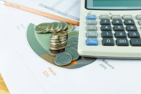 The stack of coin with business paper graphs and pencil with charts Photos