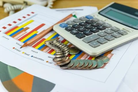 The stack of coin with business paper graphs and pencil with charts report Stock Photos