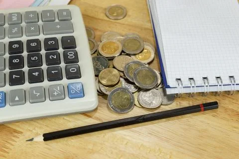 The stack of coin with calculator on wood table at office, concept Photos