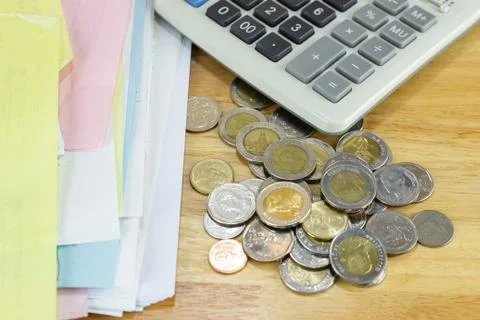 The stack of coin with calculator on wood table at office Photos