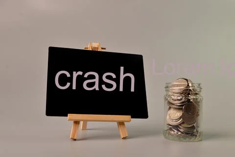 Stack of coins and chalkboard written with CRASH. Stock Photos
