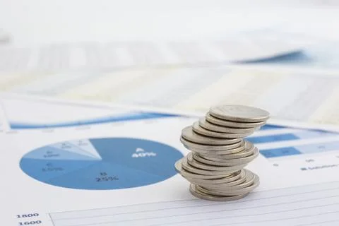 Stack of coins and charts Stock Photos