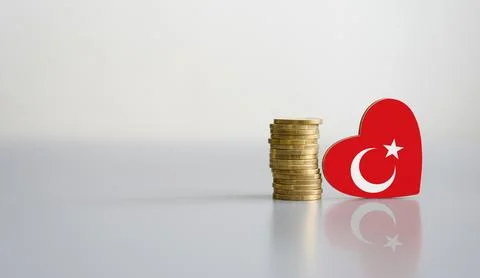 A stack of coins and the flag of Turkey in the shape of a heart. Stock Photos