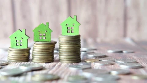 Stack of coins and green color house on table, growth of property Stock Footage 150433560