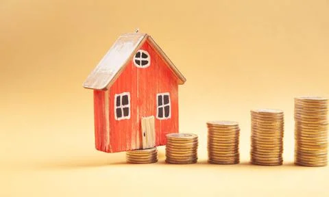 Stack of coins and house model. Saving money for buy a house Stock Photos