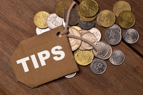 Stack of coins and memo note written with TIPS. Busienss and financial concep Stock Photos