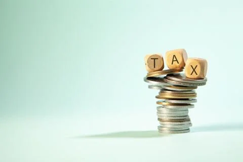 Stack of coins and TAX text on wooden cube with copy space 库存照片