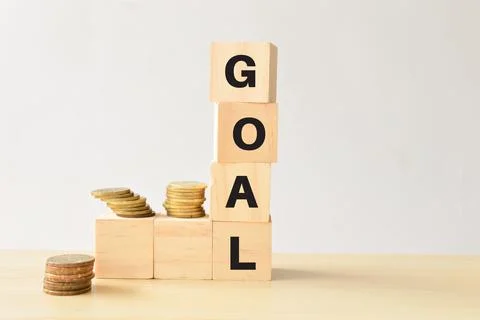 Stack of coins and wooden blocks with text GOAL Stock Photos