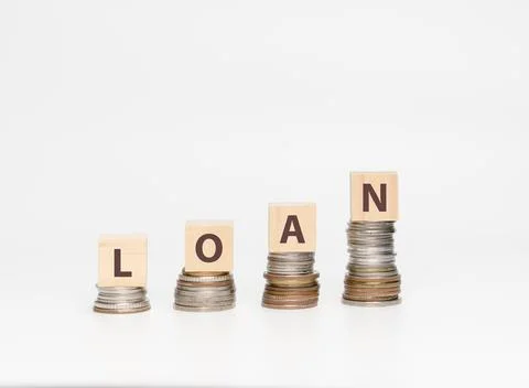 Stack coins and wooden cube with word LOAN Stock Photos