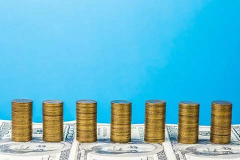 Stack coins on the background of banknotes. Unchanging graph Stock Photos