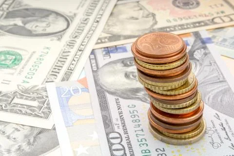 Stack of coins on background of various Euro and Dollar banknotes Foto stock