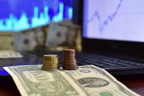 Stack of coins on blurred background of computer screen Stock Photos