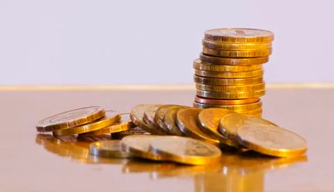 Stack of coins close-up on a gold background Stock Photos