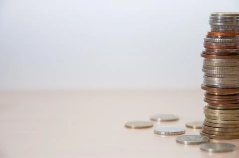 A stack of coins of different countries, color, dignity and size on the right Stock Photos