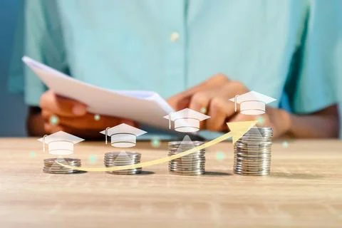 Stack of coins for education or tuition fees. Man holding a paper to read i.. Stock Photos