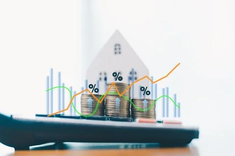 Stack of coins with glowing house icon and upward arrows, symbolizing real .. Stock Photos