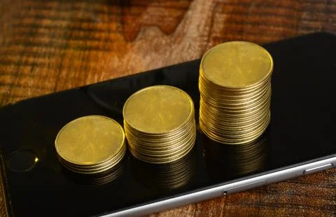 Stack of Coins going up graph on mobile screen Stock Photos