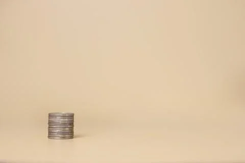 A stack of coins on a light yellow background. Investment concept Foto stock