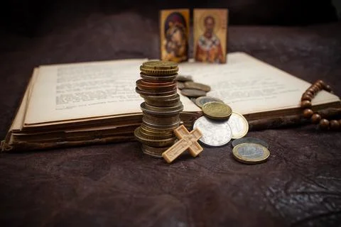 Stack of coins, opened bible and a small crucifix on leather desk, tithe co.. Stock Photos
